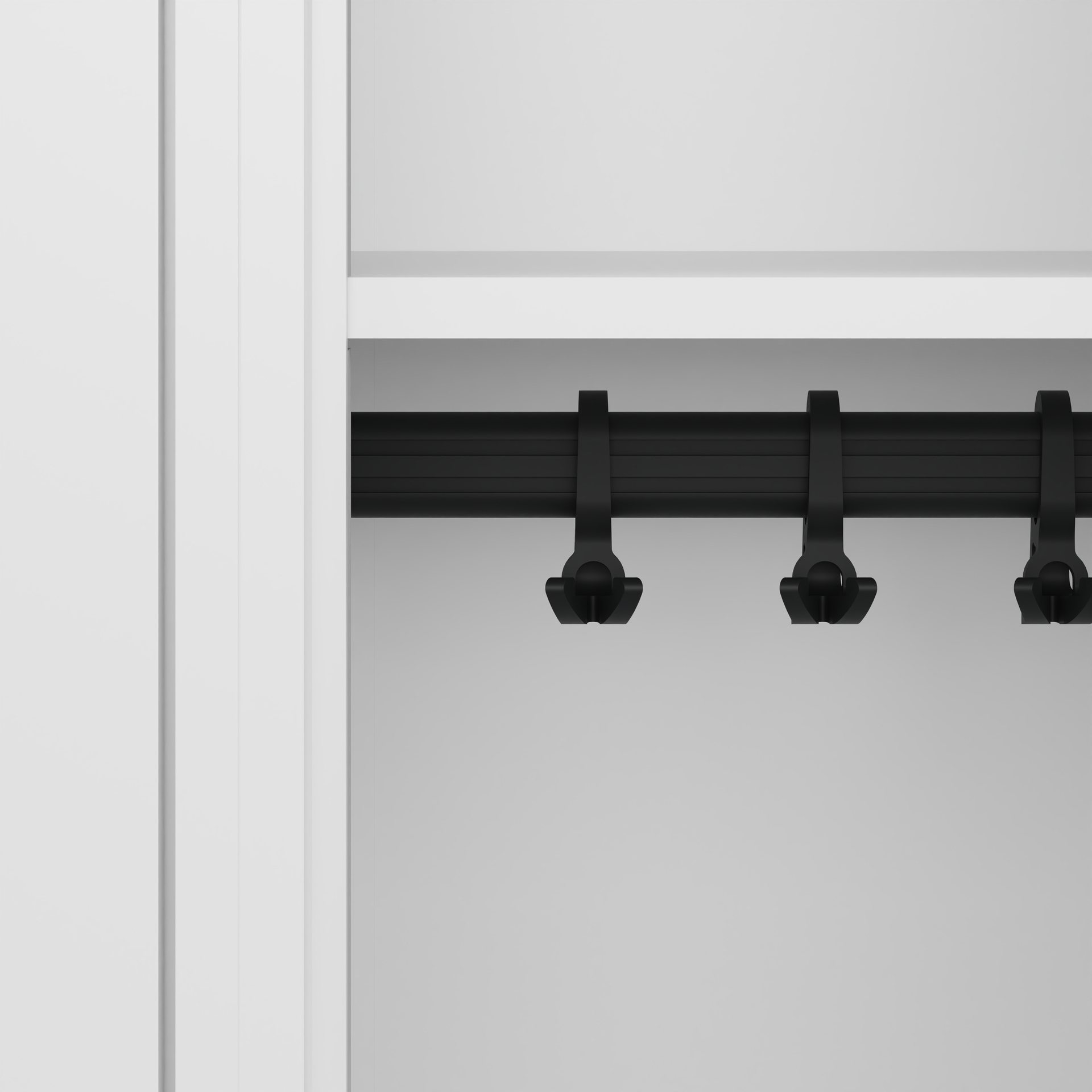 Schrankhaken hängen an schwarzer Stange im weißen Schrank.