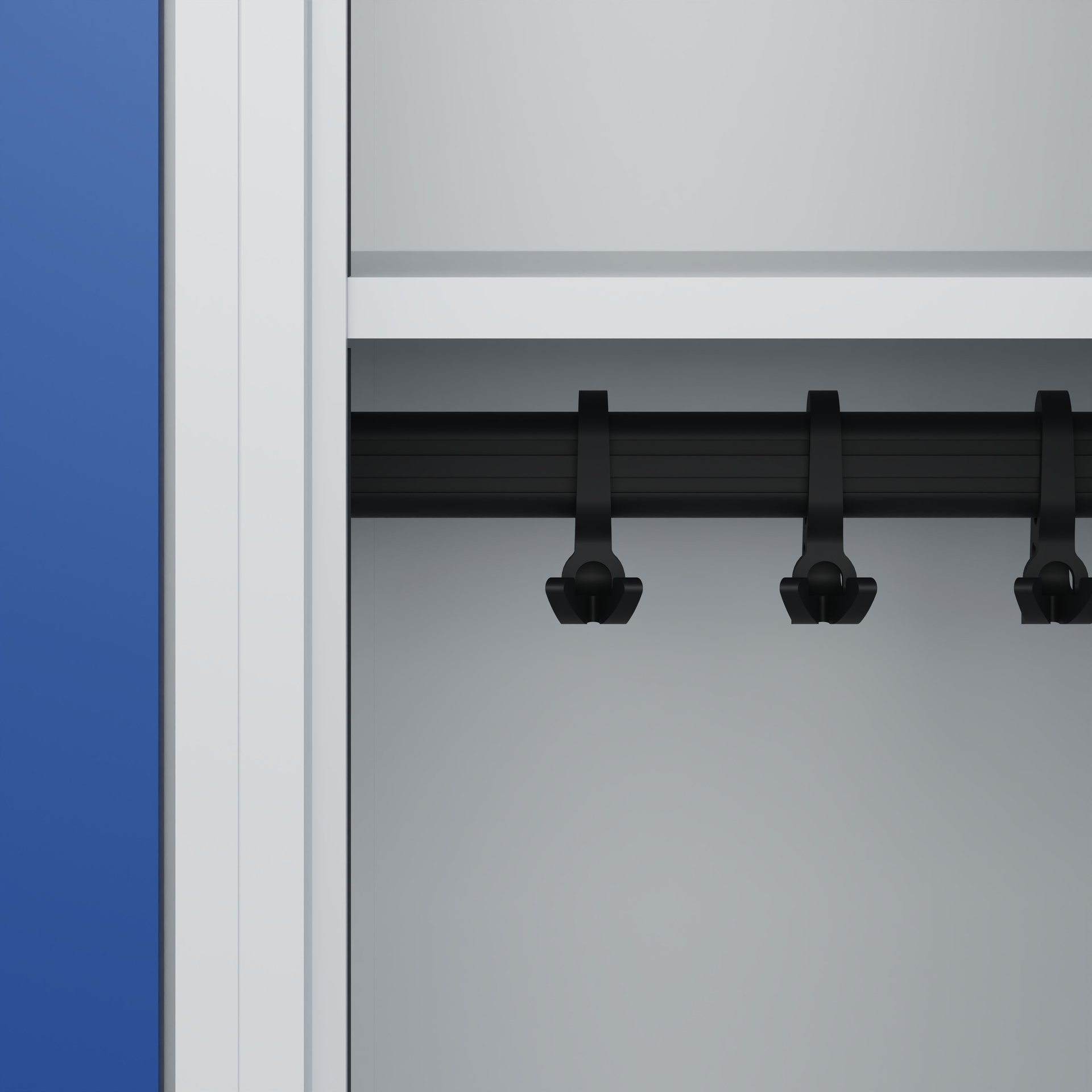 Schwarze Kleiderbügel hängen an Stange in grauem Schrank.