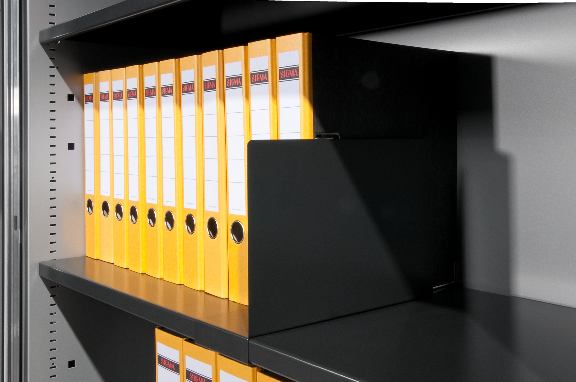Gelbe Ordner stehen aufgereiht im schwarzen Regal im Büro.